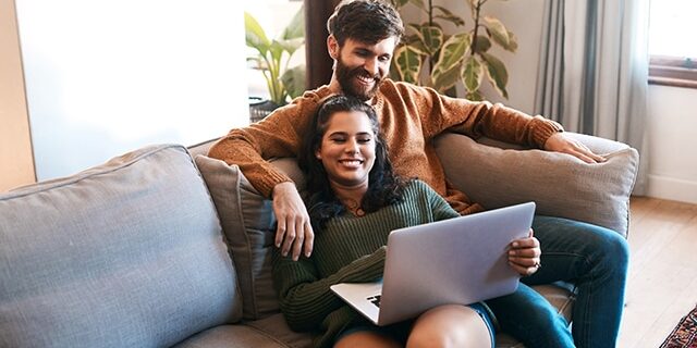 Relax, love and laptop with couple on sofa for happy, social media and streaming. Smile, internet and subscription with man and woman online in living room at home for network, news and website Relax, love and laptop with couple on sofa for happy, social media and streaming. Smile, internet and subscription with man and woman online in living room at home for network, news and website.